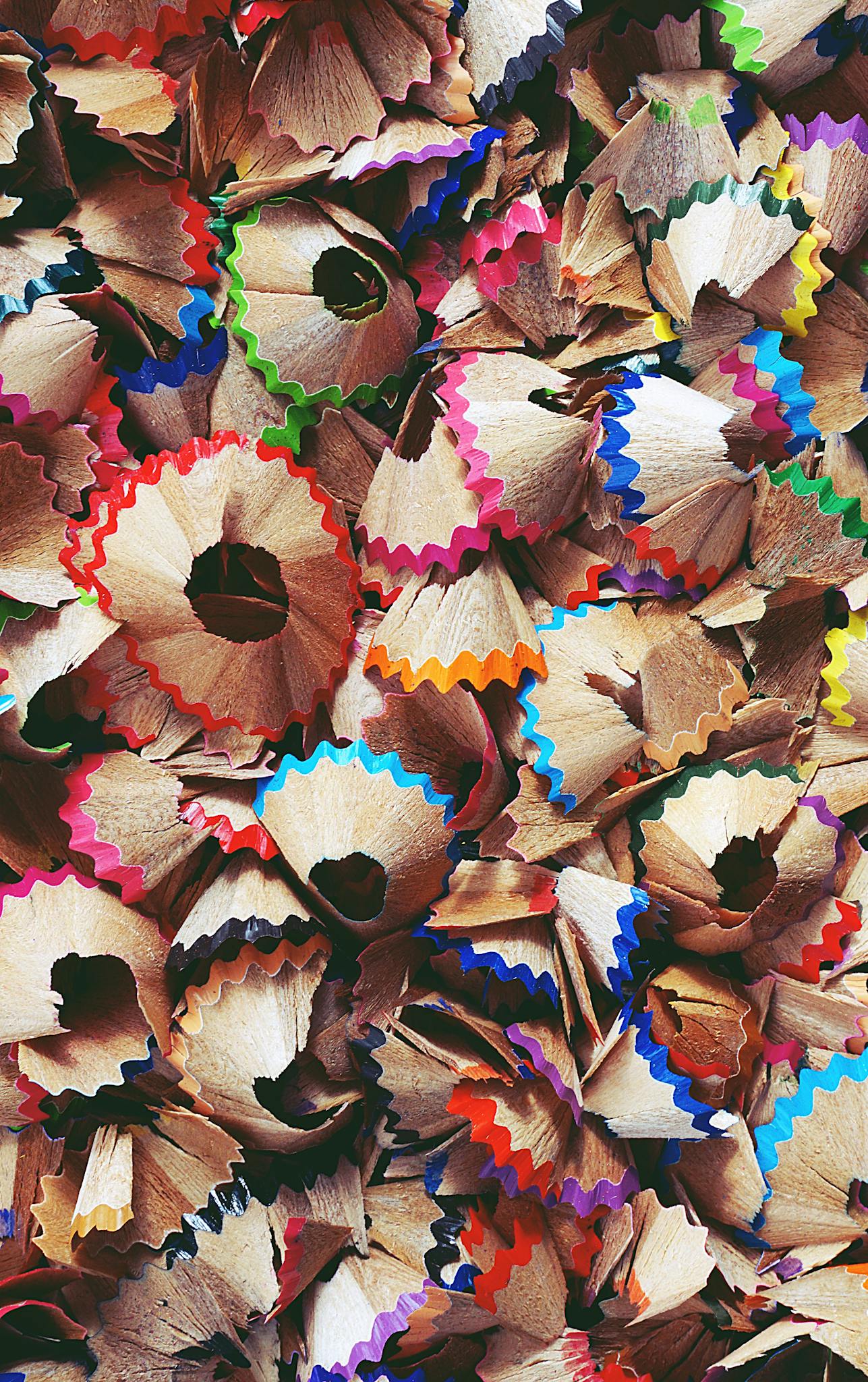 A collage of colorful pencil shavings creating a vibrant abstract pattern.